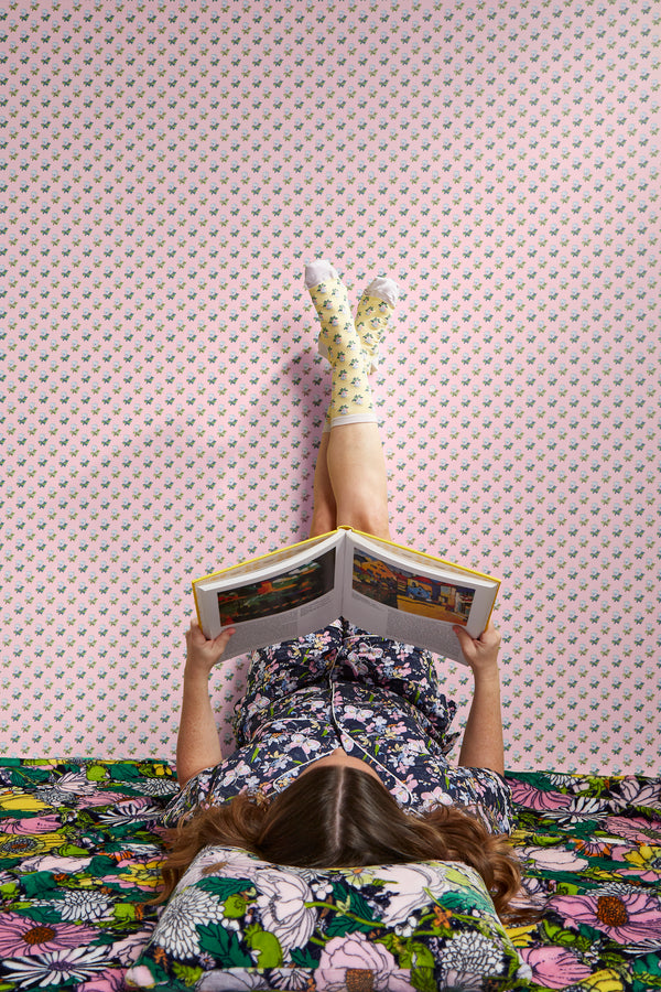 Woman laying on bed reading a book